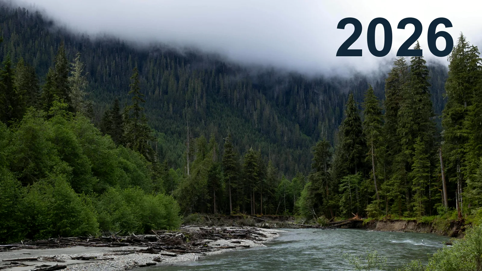 A misty river winding through the forested mountains of Washington with 2026 in the sky
